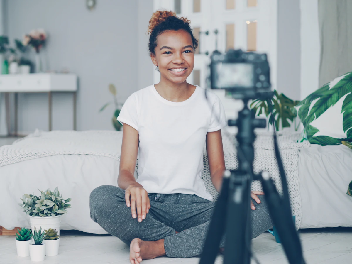 Content creator filming herself with a camera on a tripod.