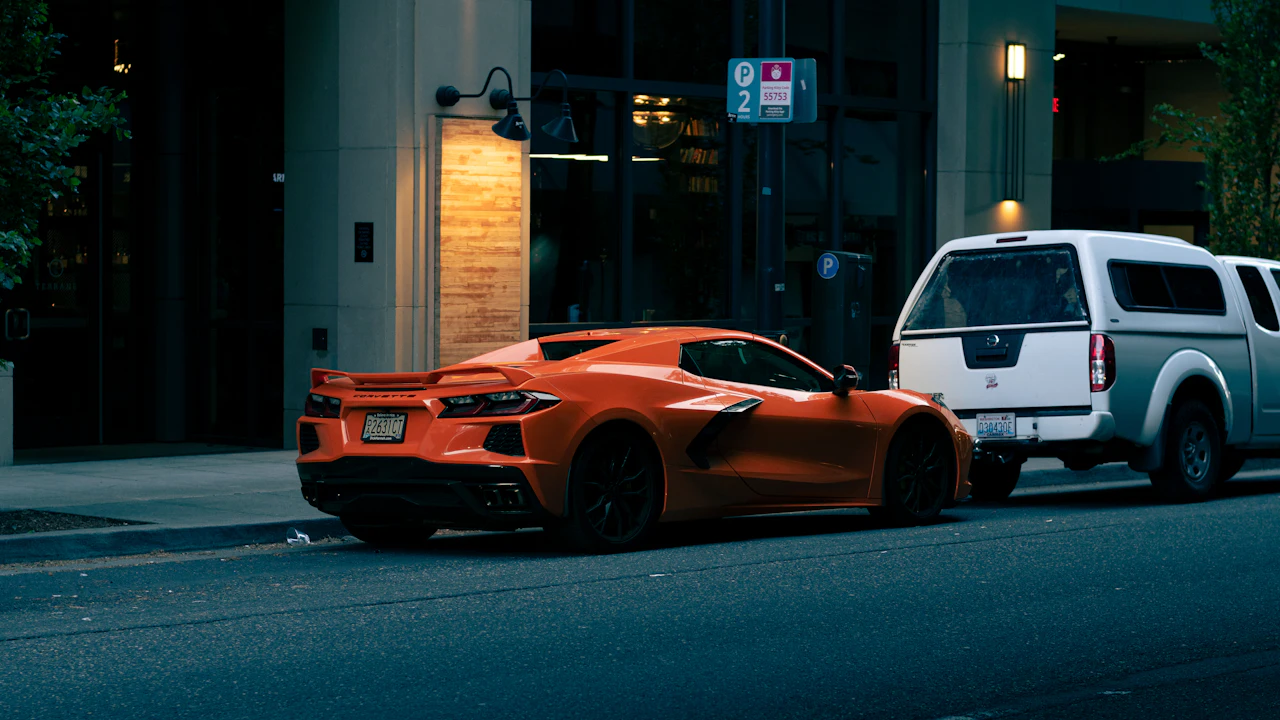 Orange sports car parked on a street at night.