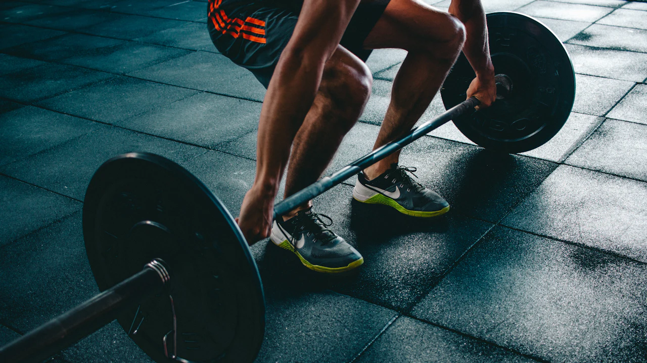 Person setting up a barbell deadlift.